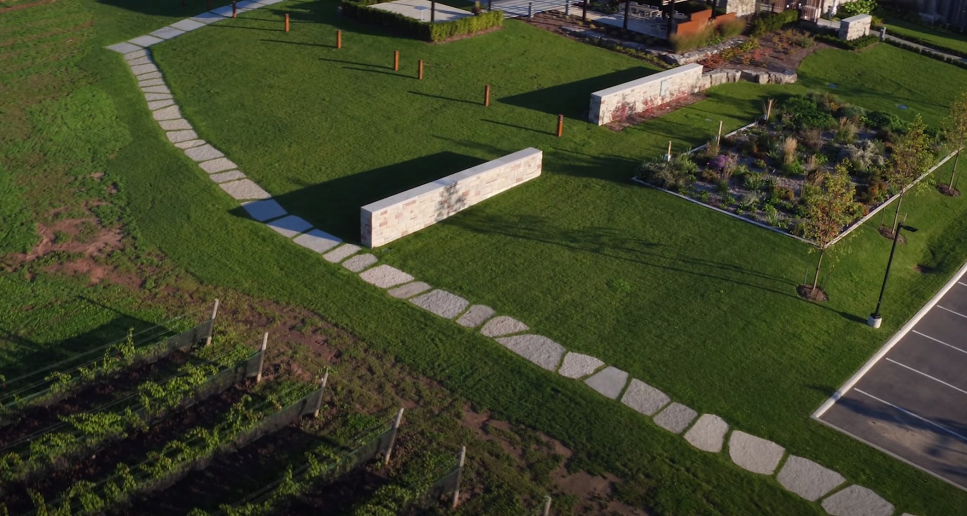 Professional landscape design with geometric hardscaping and pristine lawn maintenance Aerial view of modern landscaping with geometric stone pathways and manicured lawn areas