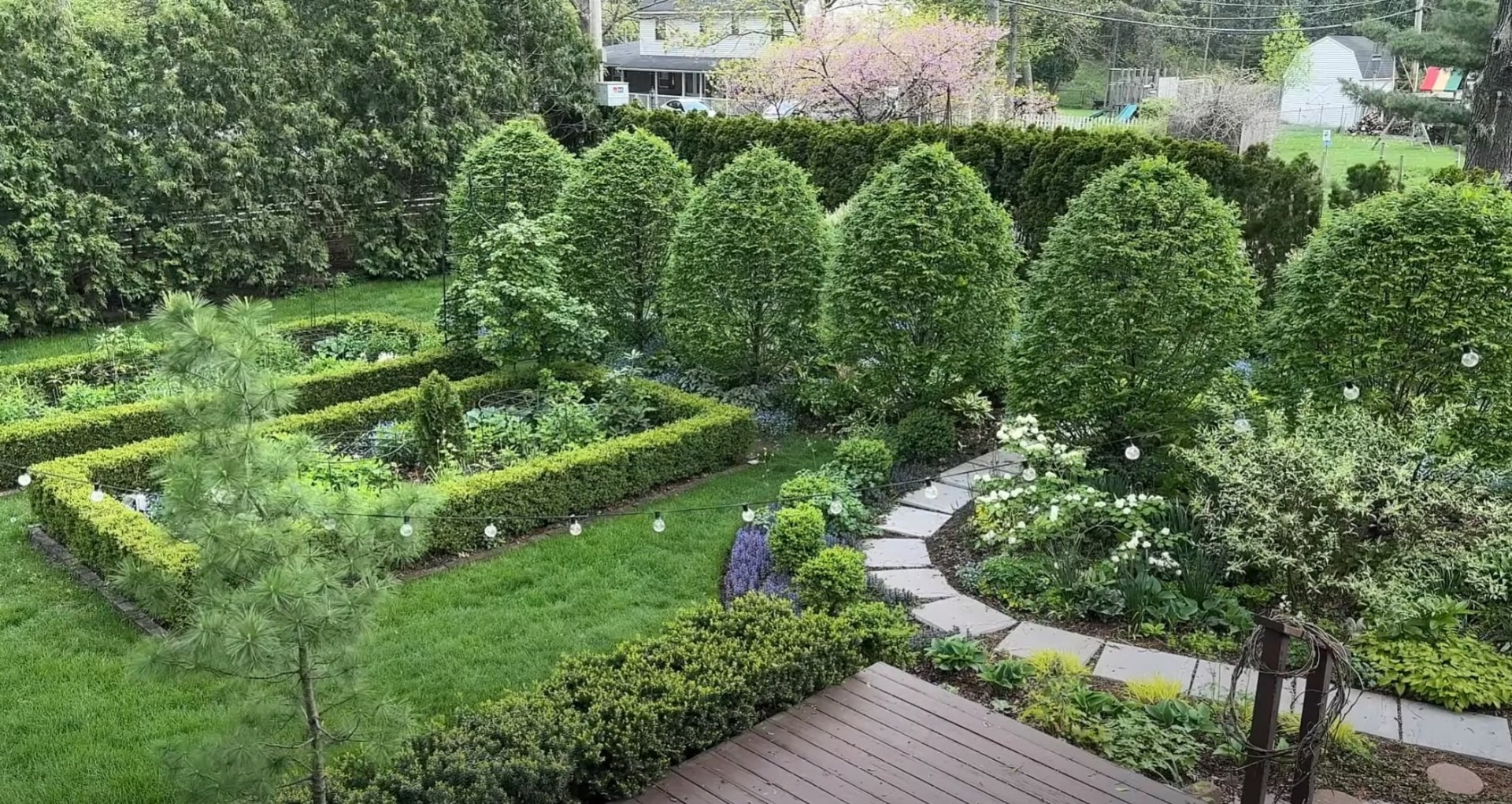 Comprehensive landscape installation with formal garden design and lighting solutions Elevated view of formal garden with structured landscaping, pathways, and outdoor lighting