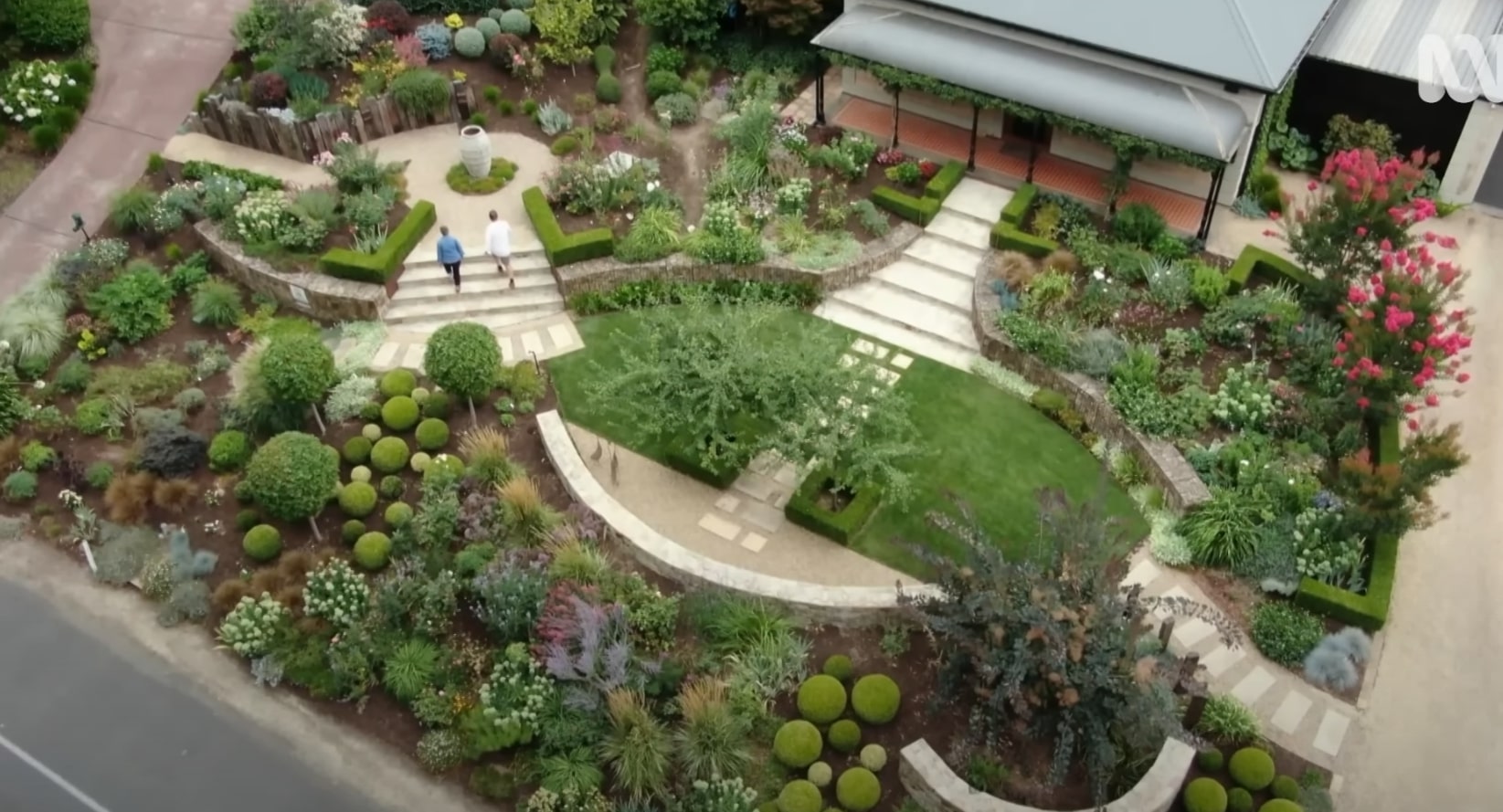 Award-winning landscape design showcasing curved hardscaping and artistic plant arrangements Aerial view of elaborate landscape design with curved pathways and artistic garden layout